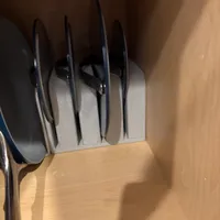Customer-uploaded image. Click to see more details. The image represents: Kitchen drawer organizer holding several pots and pans with handles visible, stored vertically in wooden cabinet