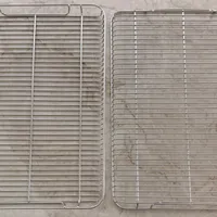 Customer-uploaded image. Click to see more details. The image represents: Two stainless steel wire cooling racks or baking racks placed side by side on a gray surface, showing their grid pattern construction.