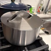 Customer-uploaded image. Click to see more details. The image represents: Stainless steel saucepan with lid on stovetop in kitchen