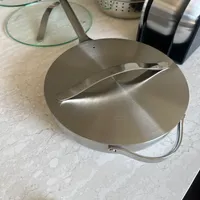 Customer-uploaded image. Click to see more details. The image represents: Stainless steel cookware including pots with lids and a steamer basket arranged on a marble countertop