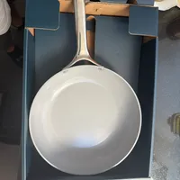 Customer-uploaded image. Click to see more details. The image represents: A white ceramic non-stick frying pan with a stainless steel handle displayed in its packaging box. The box reads "Essential Cookware, Made Better" with text indicating it's non-toxic coating, non-stick, and eco-friendly. The 10.5 inch fry pan is shown from above inside the blue and tan colored retail box.