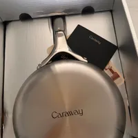 Customer-uploaded image. Click to see more details. The image represents: A stainless steel Caraway cookware pan in its original packaging box with product tags attached
