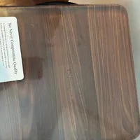 Customer-uploaded image. Click to see more details. The image represents: A wooden cutting board with a wood grain pattern and a white product label attached to the upper left corner