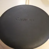 Customer-uploaded image. Click to see more details. The image represents: A black non-stick frying pan with white handle showing the Caraway brand name embossed on the cooking surface