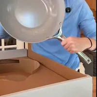 Customer-uploaded image. Click to see more details. The image represents: A person in a blue shirt pouring liquid from a gray pan into a white container on a wooden surface.