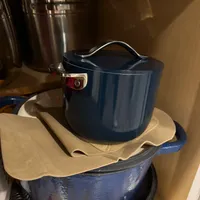 Customer-uploaded image. Click to see more details. The image represents: Blue ceramic cookware and kitchen items stacked on a counter, including a pot with lid and various containers