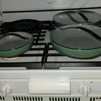 Customer-uploaded image. Click to see more details. The image represents: Green cookware pans with glass lids sitting on a white gas stovetop