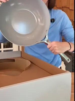 Customer-uploaded image. Click to see more details. The image represents: A person in a blue shirt pouring liquid from a gray pan into a white container on a wooden surface.