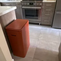 Customer-uploaded image. Click to see more details. The image represents: Modern kitchen with stainless steel appliances, gray cabinets, white subway tile backsplash, and a bright orange retro-style refrigerator on beige tile flooring
