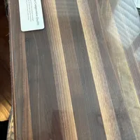 Customer-uploaded image. Click to see more details. The image represents: A wooden cutting board with natural wood grain patterns and a white label in the upper left corner