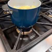 Customer-uploaded image. Click to see more details. The image represents: Blue pot with boiling water and corn on the cob cooking on a gas stovetop