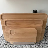 Customer-uploaded image. Click to see more details. The image represents: Three wooden cutting boards of different sizes displayed in a metal stand on a granite countertop