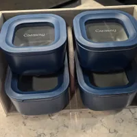 Customer-uploaded image. Click to see more details. The image represents: Four blue Caraway storage containers with light blue lids arranged in a beige fabric organizer box on a marble countertop.