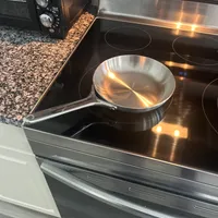 Customer-uploaded image. Click to see more details. The image represents: Stainless steel frying pan sitting on a glass-top electric stove in a modern kitchen