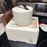 Customer-uploaded image. Click to see more details. The image represents: White ceramic pot with lid sitting on its product box on a kitchen counter next to a microwave and knife block