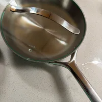 Customer-uploaded image. Click to see more details. The image represents: Stainless steel frying pan with glass lid and metal handle on kitchen counter