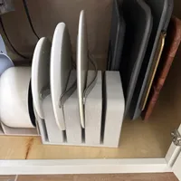 Customer-uploaded image. Click to see more details. The image represents: Kitchen cabinet organizer holding various cutting boards and baking sheets stored vertically on a shelf