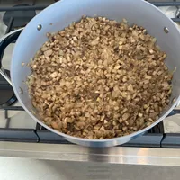 Customer-uploaded image. Click to see more details. The image represents: A large white pot filled with diced sautéed mushrooms cooking on a stovetop burner
