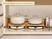 Caraway cream enameled cast iron cookware stacked on wooden organizers inside a cabinet.