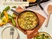 Caraway enameled cast iron skillet serving a vegetable dish on a dining table.
