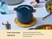 Caraway lidded Navy petite cooker on a woven trivet on a dining table.