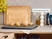 Three sizes of wooden cutting boards standing behind a rack of baked goods.