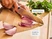 Hand slicing a red onion with a kitchen knife on a wooden cutting board.