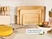 Caraway wooden cutting boards stored upright in an organizer beside utensils and cookware.
