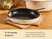 Caraway empty Cream enameled cast iron large skillet on a folded towel on a counter.