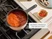 Caraway enameled cast iron mini sauce pan holding tomato sauce on a stove.