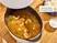 Caraway oval enameled cast iron Dutch oven filled with seafood stew with its lid lifted.