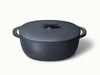 Caraway 8 qt enameled cast iron oval dutch oven in Midnight with a matching lid.