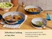 Caraway navy ceramic fry pans and a sauté pan holding cooked food on a dining table.