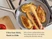 Caraway wooden utensils turning chicken in a ceramic large fry pan, viewed from above.