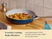 Caraway navy ceramic fry pan serving mixed vegetables on a dining table.