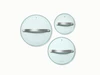Three clear glass cookware lids with silver-tone handles, viewed from above.