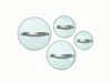 Four clear glass cookware lids with silver-tone handles, viewed from above.