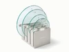 Caraway glass lid set of 4 with silver-tone handles with lids arranged in a storage organizer.