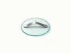 Caraway clear glass cookware lid with a silver-tone handle, viewed at an angle.