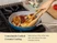 Caraway wooden tongs turning chicken in a Navy ceramic large fry pan.