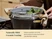 Hands using towels to lift a steamer containing leafy vegetables from a Black Dutch oven.