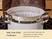 Caraway large stainless steel steamer insert nested in a Dutch oven on a stove.