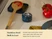 Caraway navy mechanical kitchen timer beside a spoon rest and tomato on a counter.