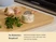 Caraway cream mechanical kitchen timer on a cutting board beside herbs and garlic.