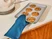 Caraway navy oven mitt holding a baking sheet of cookies.