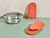 Caraway perracotta oven mitts beside a stainless steel steamer.