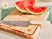 Caraway cream-handled kitchen knife beside sliced watermelon on a wooden cutting board.