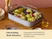 Caraway roasting pan with a rack holding cabbage and other roasted vegetables on a table.