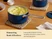 Caraway navy ceramic sauce pan filled with mashed potatoes on a woven trivet.