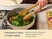 Caraway wooden tongs stirring leafy greens in a Cream ceramic small sauté pan.